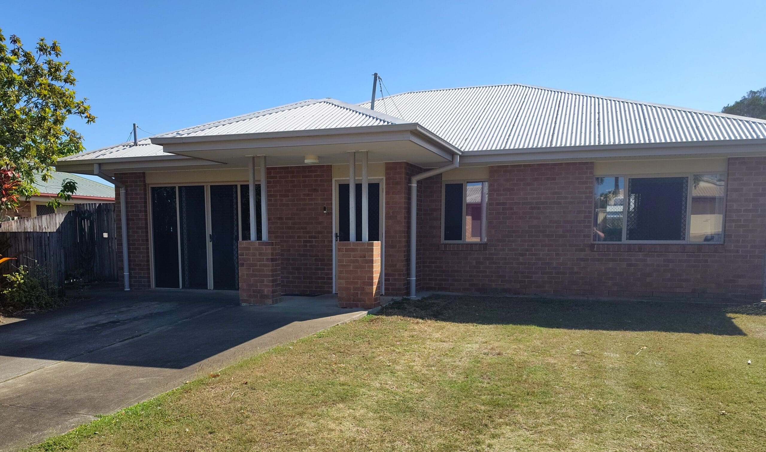 SIL Home in Mackay, Inverness Court Beaconsfield exterior with brick facade, metal roof, covered entry, driveway and front lawn by Australia's leading disability accommodation provider.
