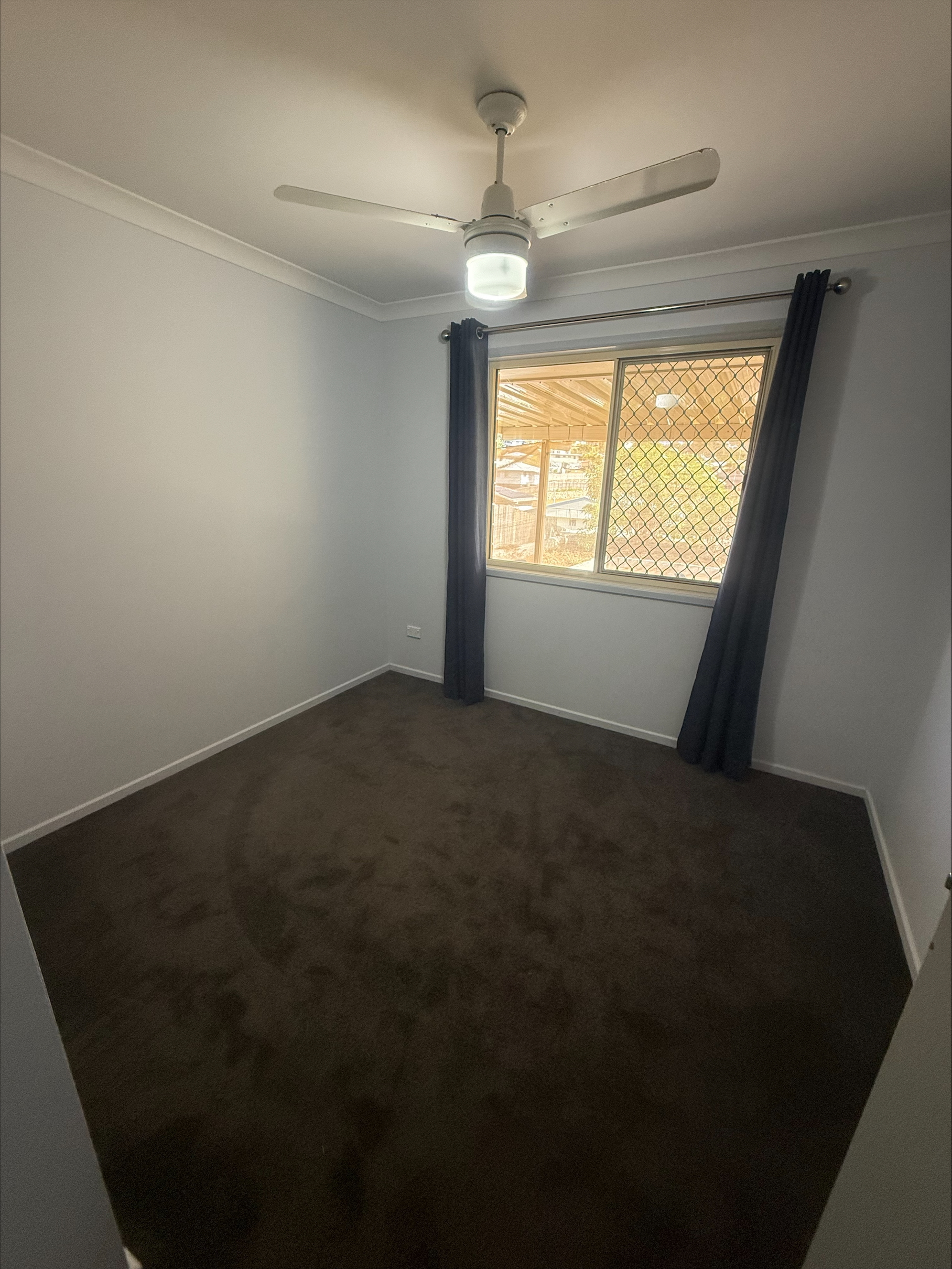 Bedroom with a ceiling fan in Toolooa home, QLD