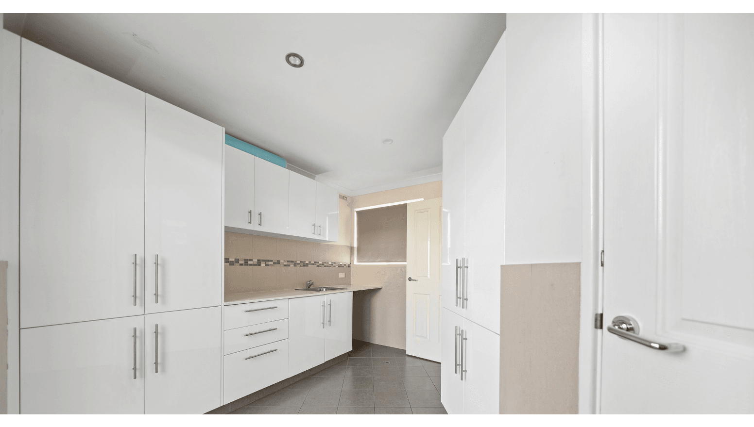 Spacious, accessible kitchen in a Supported Independent Living (SIL) Home in Morley, Australia, featuring white gloss cabinets, ample storage, and clear circulation, part of Australia’s leading disability accommodation provider.