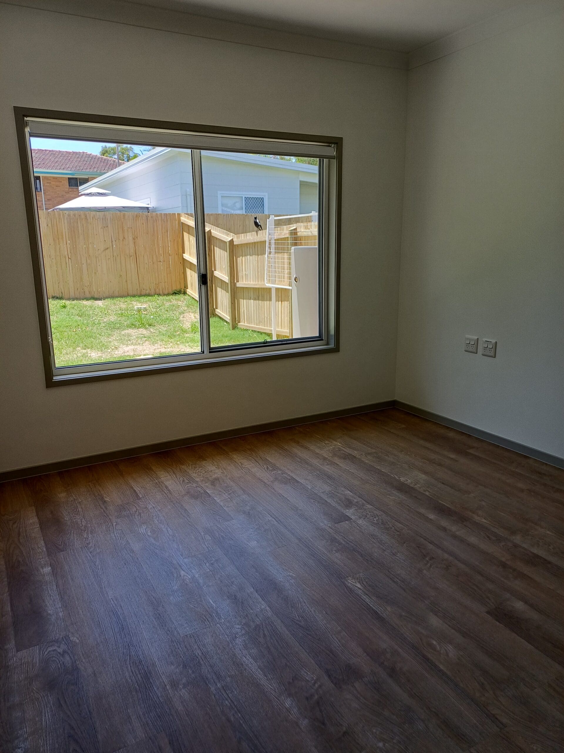 Spacious, accessible room in Purpose-Built High Physical Support Living in Cleveland, Langdon Street, featuring large window, dark wood flooring, and clear circulation, part of Australia’s leading disability accommodation provider.