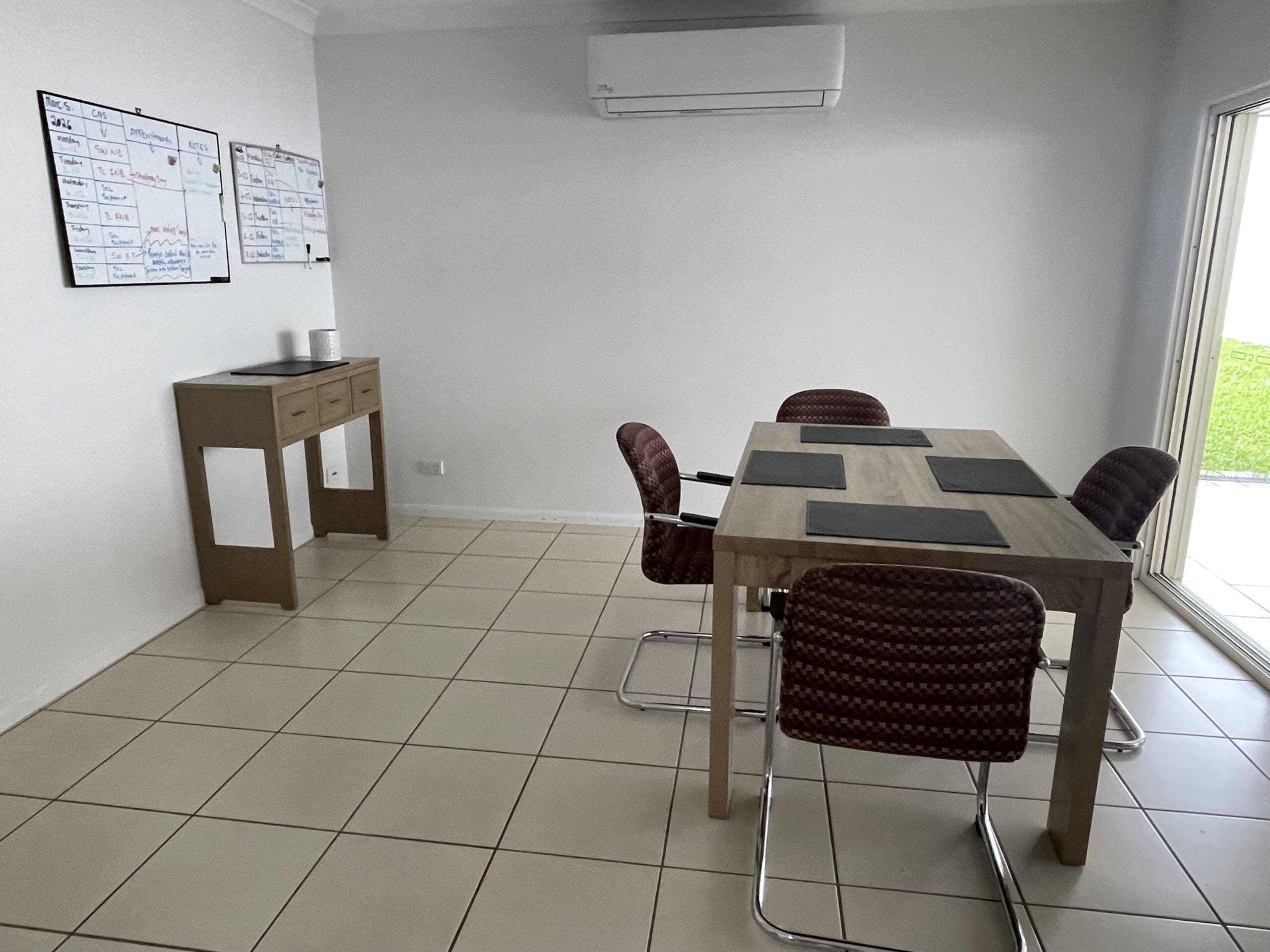 Dining area in Spacious SIL home in leafy 23 Norfolk Circuit, Redlynch featuring accessible table, whiteboards for scheduling, and clear circulation, part of Australia’s leading disability accommodation provider.