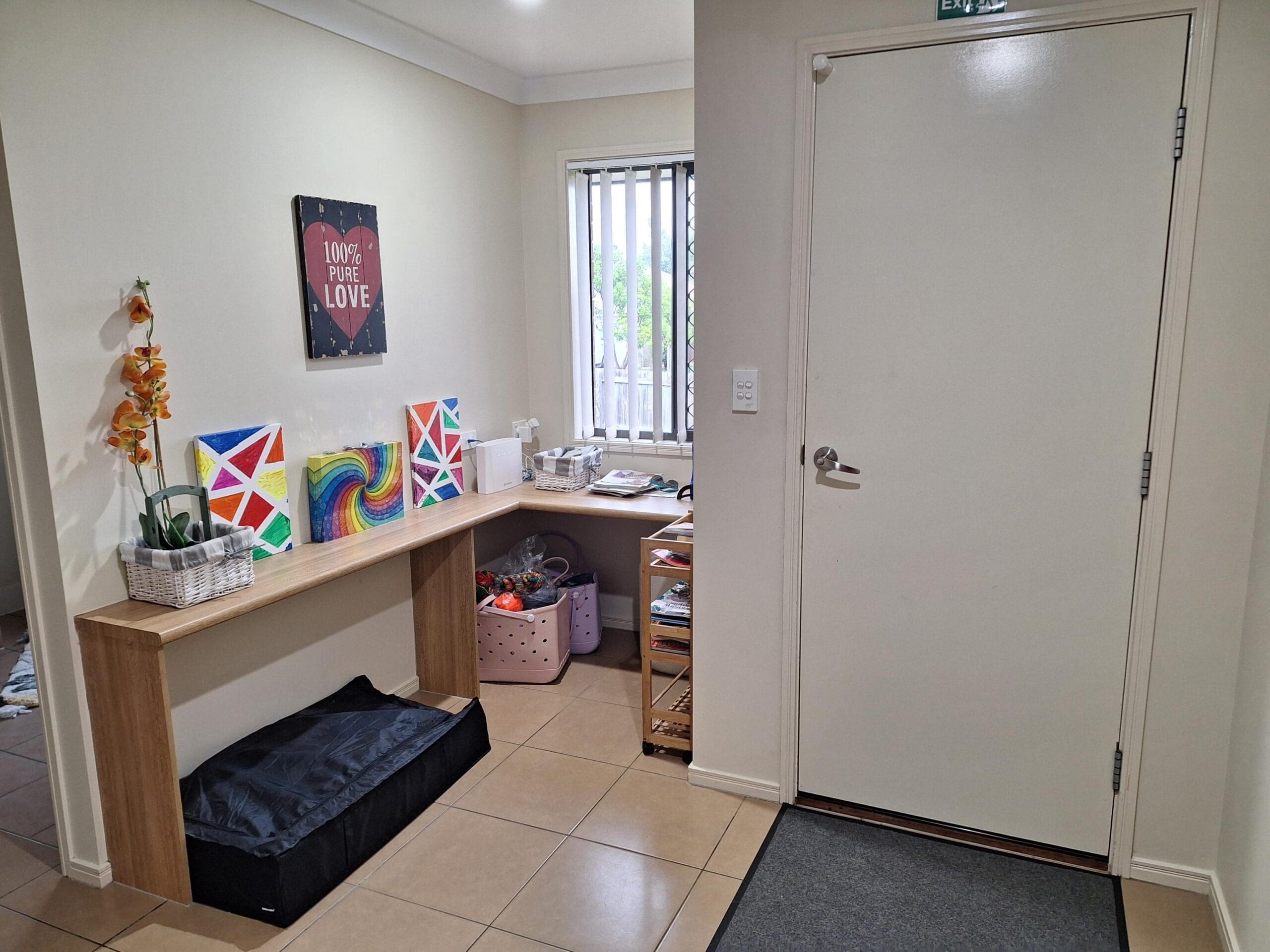 Hallway in welcoming and cosy SIL in Brassall, Ipswich, featuring artwork, bench storage, and accessible door, part of Australia’s leading disability accommodation provider.