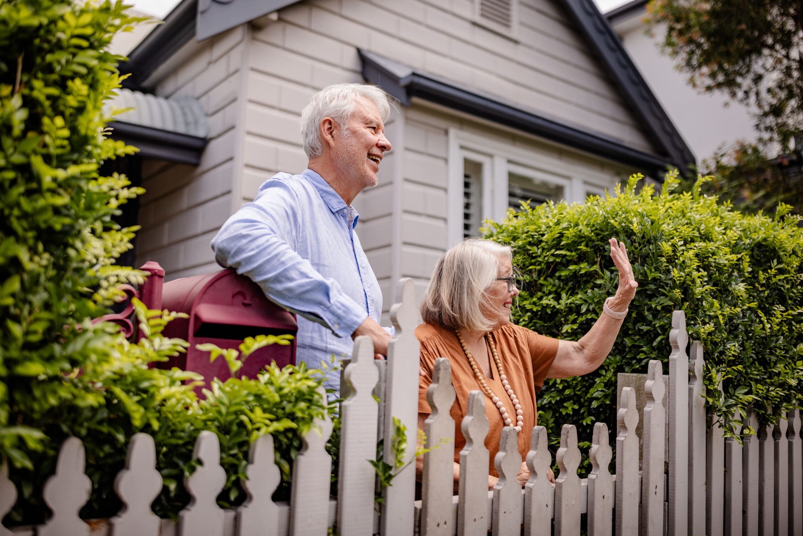 Elderly couple enjoying a sunny afternoon by the fence