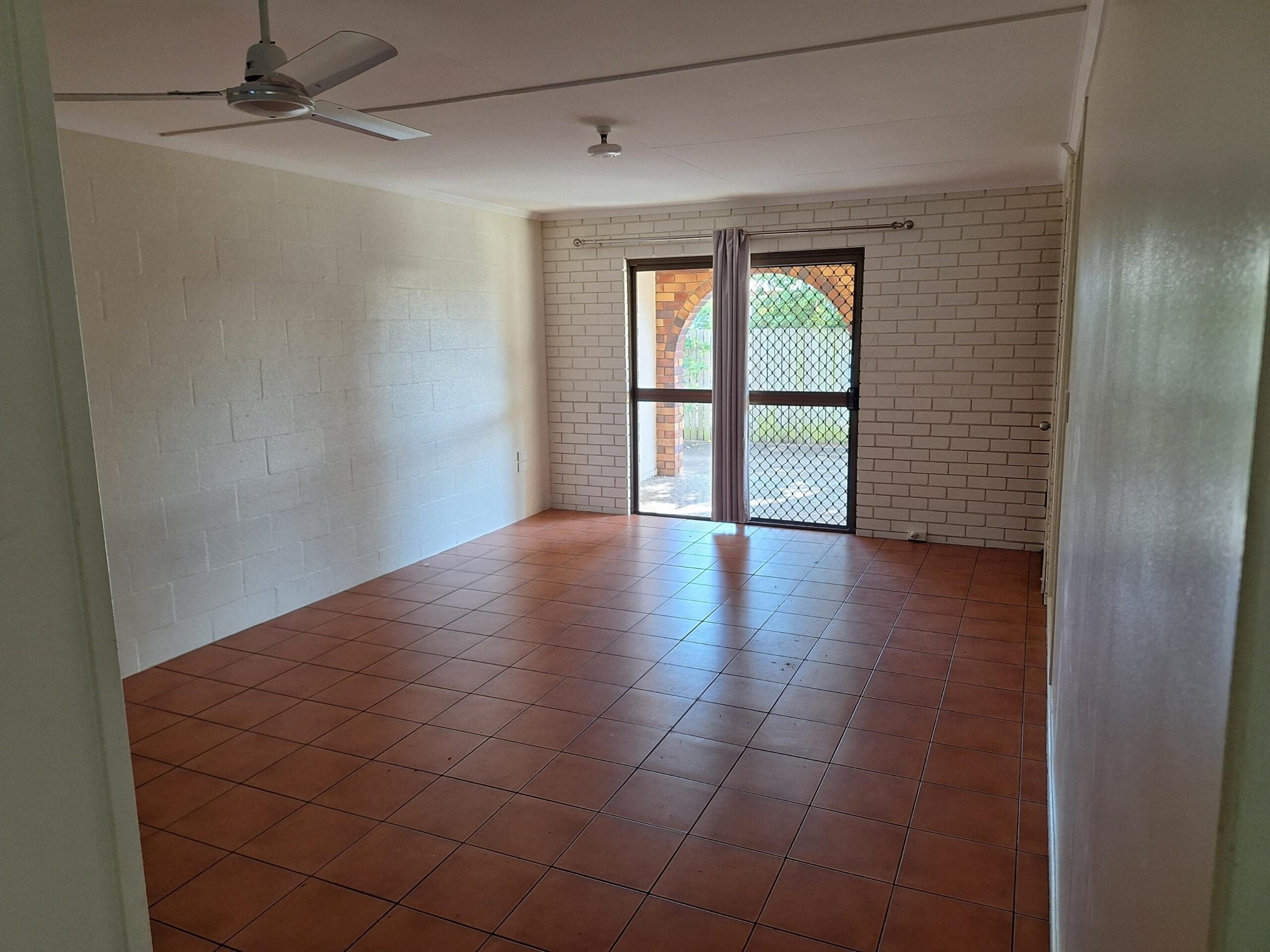 Private SIL unit living in a prime Millbank location with tiled open living area, ceiling fan and sliding screen door by Australia's leading disability accommodation provider.