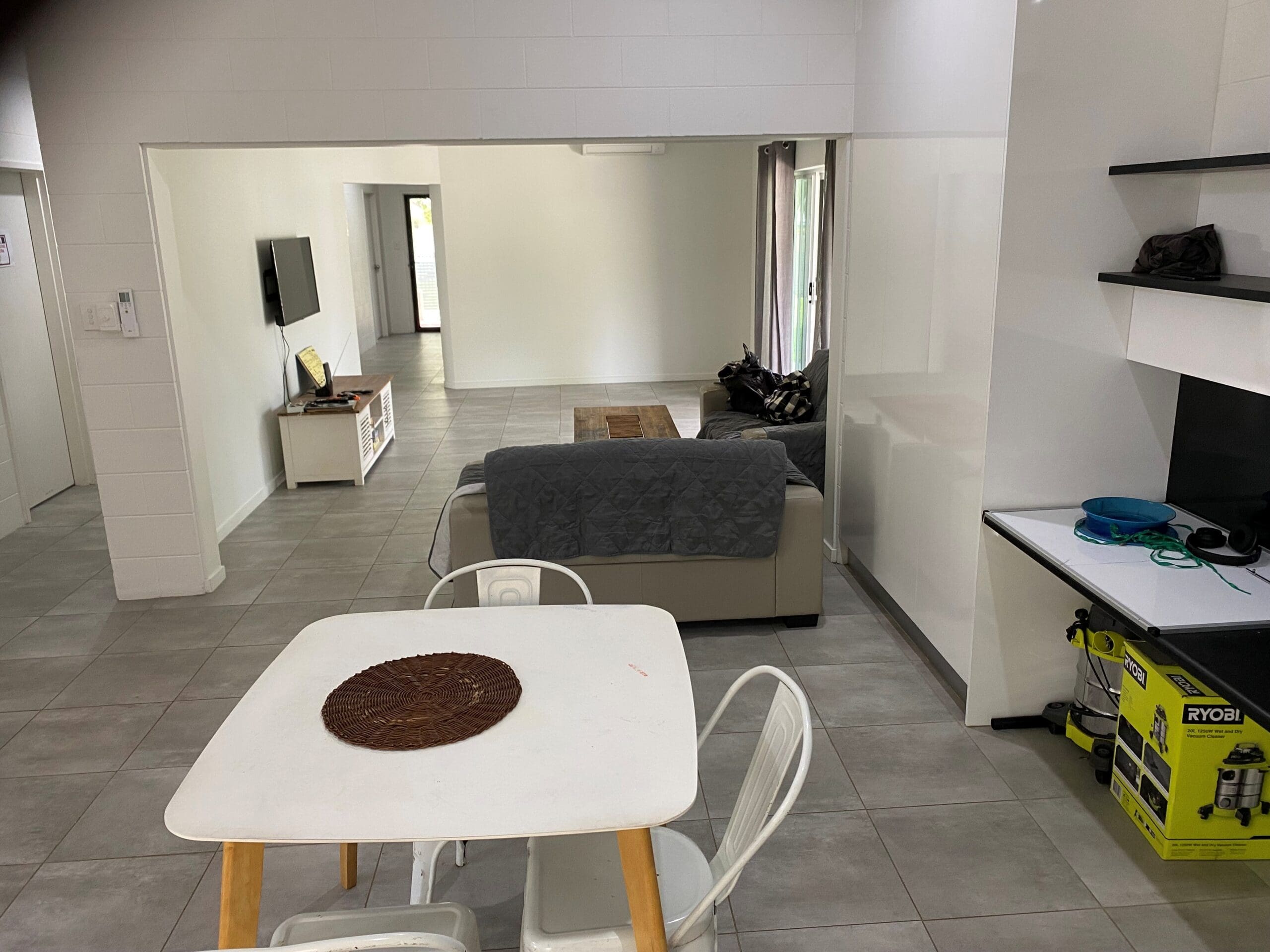 SIL Vacancy in Bentley Park, Cairns, Lorraine Close, Bentley Park dining and living area with tiled floor, dining table, sofa and TV by Australia's leading disability accommodation provider.