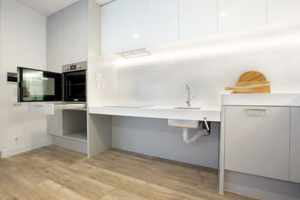 New SDA apartments in the heart of Joondalup with OSS, Grand Blvd, Joondalup kitchen with accessible sink, white cabinetry, microwave and oven by Australia's leading disability accommodation provider.