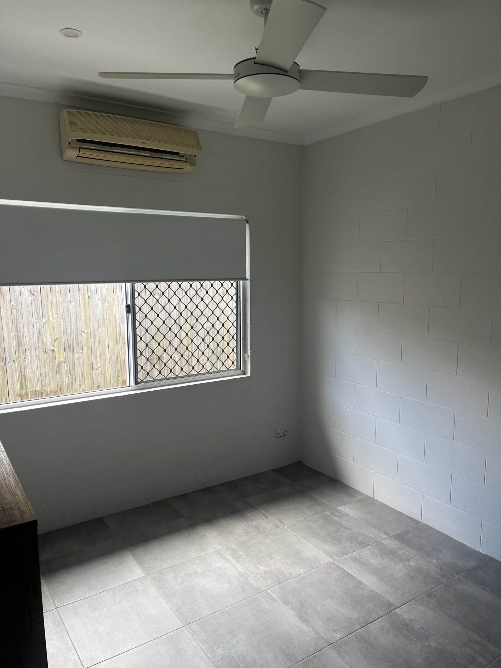 SIL Vacancy in Bentley Park, Cairns, Lorraine Close, Bentley Park bedroom with ceiling fan, air conditioning, tiled floor and screened window by Australia's leading disability accommodation provider.
