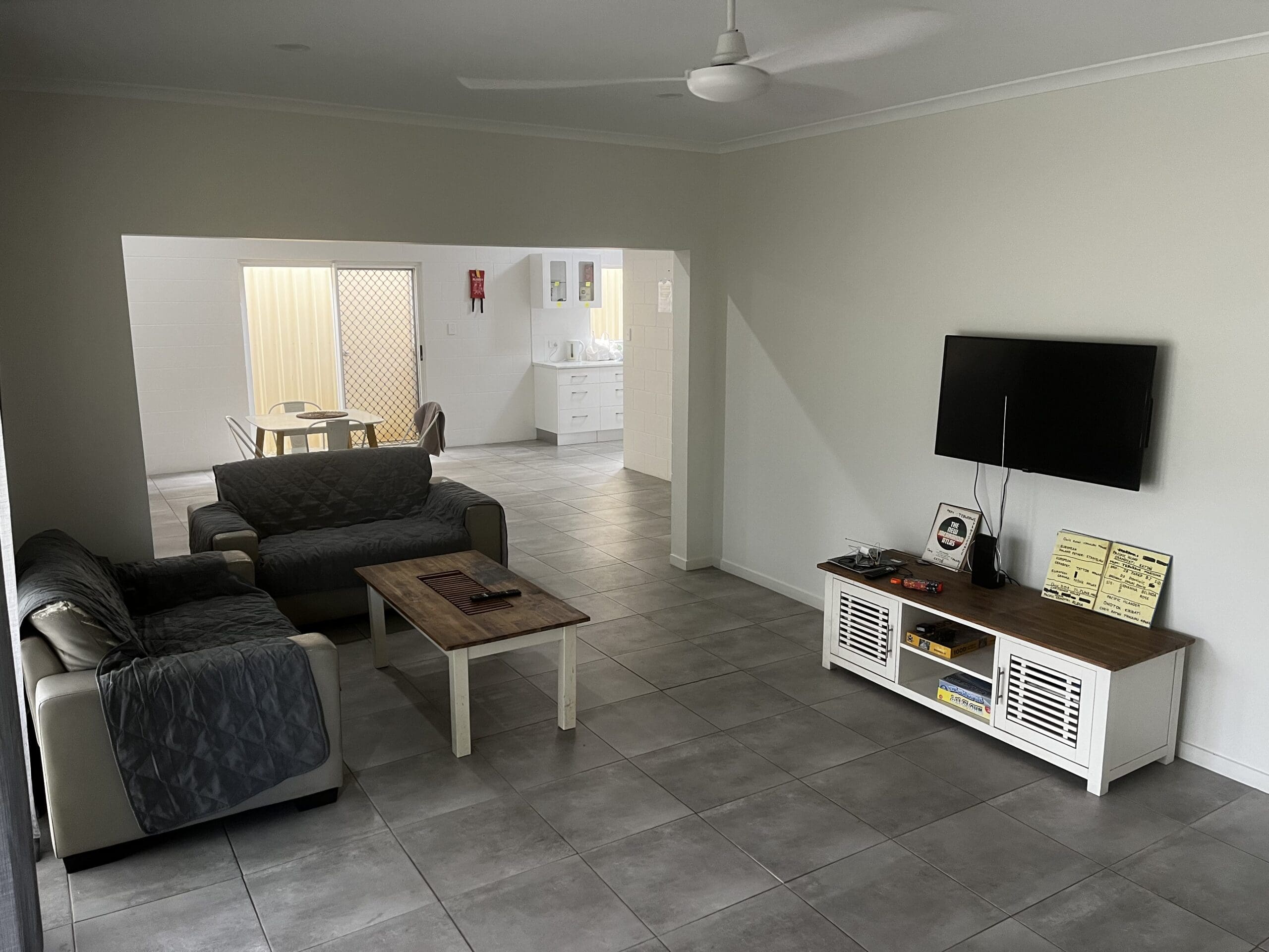 SIL Vacancy in Bentley Park, Cairns, Lorraine Close, Bentley Park living room with tiled floor, ceiling fan, air conditioning and sliding door by Australia's leading disability accommodation provider.