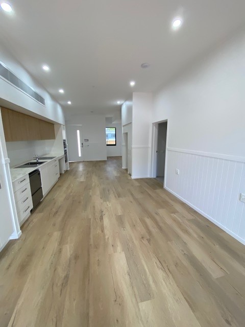 SDA vacancy north of Rockhampton, Kerrigan St Frenchville with open-plan kitchen, living area, timber-look flooring and recessed lighting by Australia's leading disability accommodation provider.