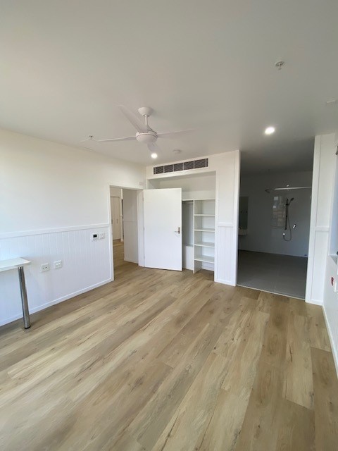 SDA vacancy north of Rockhampton, Kerrigan St Frenchville bedroom with ceiling fan, built-in shelving, timber-look flooring and open ensuite by Australia's leading disability accommodation provider.
