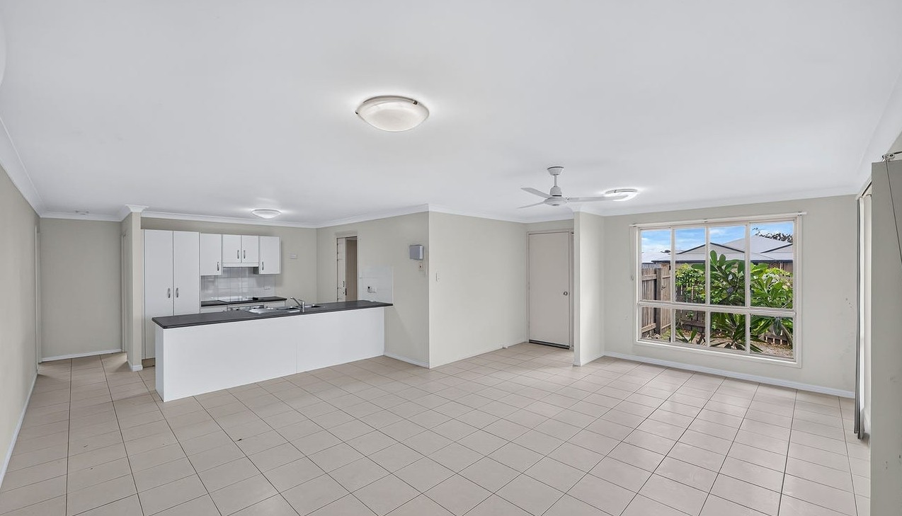 Roomy SIL home in Gracemere, Joseph St Gracemere with open-plan kitchen, tiled living area, ceiling fan and large window by Australia's leading disability accommodation provider.
